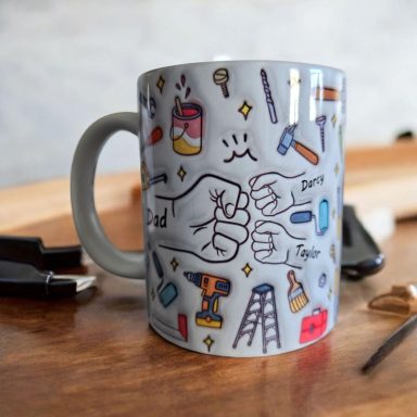 A mug decorated with various hand tools and illustrations of fists.