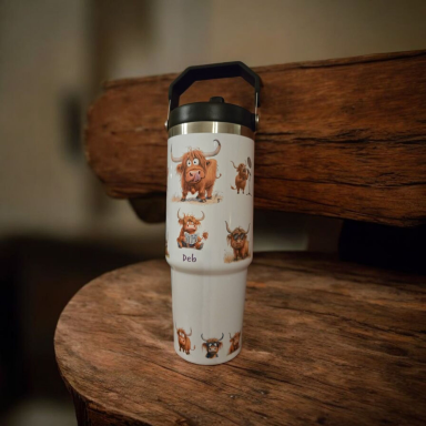 White travel mug with animal designs, featuring lions and other playful illustrations.